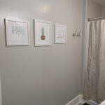 Showing bathroom wall with artwork.